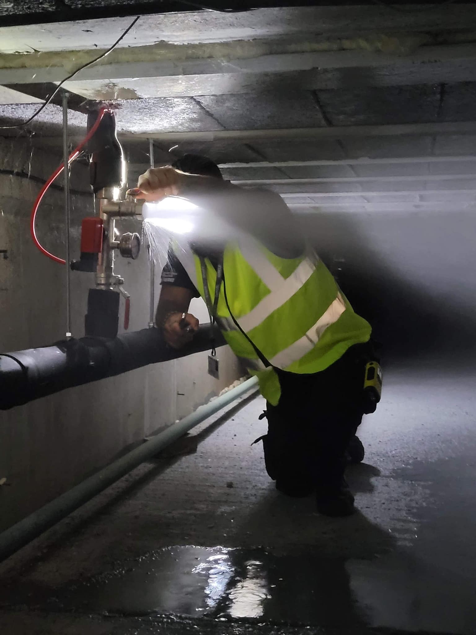 A photo of a man wearing a hi-viz jacket conducting a pipe inspection